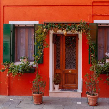 Venice, İtalya - 28 Aralık 2018: Renkli ev cepheler Burano Adası'nın çiçek ve Noel süsleri