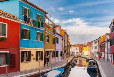 Venice, İtalya - 28 Aralık 2018: Tipik sokak sahne Burano Adası'nın cephe renkli evler ve bir kanal tekne ile asılı bir çamaşırhane ile