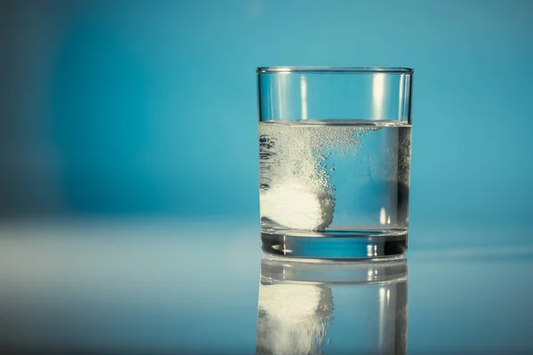 Egy pezsgő tablettát egy pohár vízben — Stock Fotó