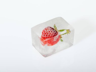Beyaz arka planda buzda donmuş çilek. Dondurulmuş meyve kavramı.