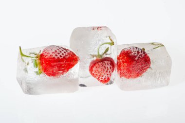 Beyaz arka planda buzda donmuş çilek. Dondurulmuş meyve kavramı