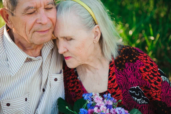 happy and very old people sitting in the park