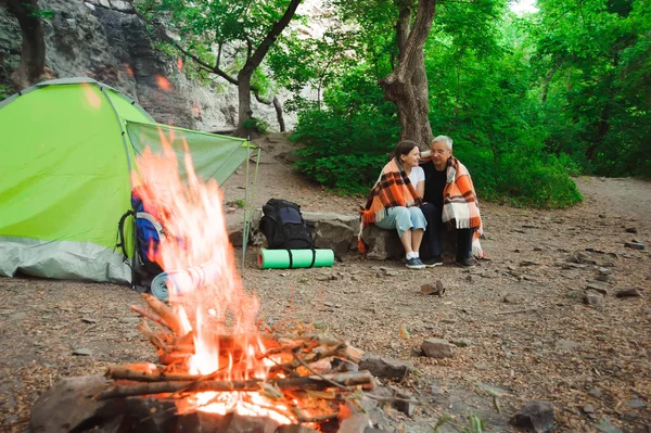 Tent camping couple romantic sitting by bonfire night