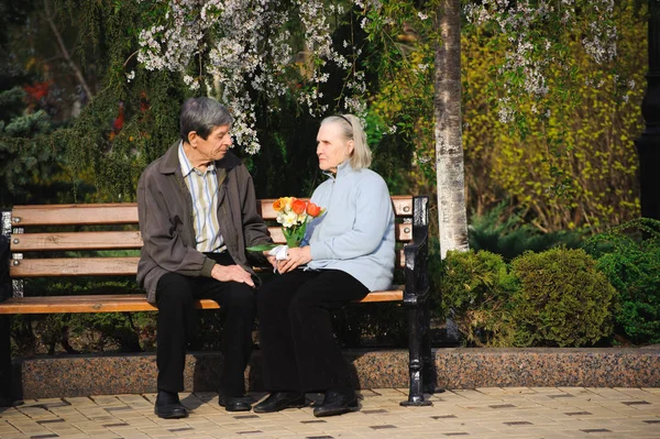 beautiful happy old people sitting in the autumn park