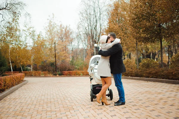Mom and Dad hugging in the autumn park.