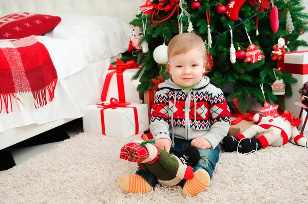 Family New year celebration. The little boyl at the Christmas tree.