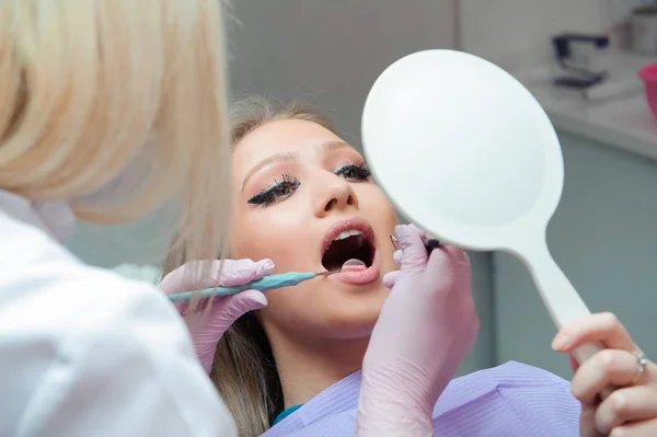 Young woman having medical checkup in the dentist office by the doctor.