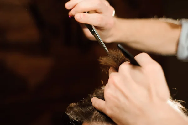 Master cuts hair and beard of men in the barbershop