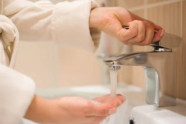 Washing of hands with soap under running water