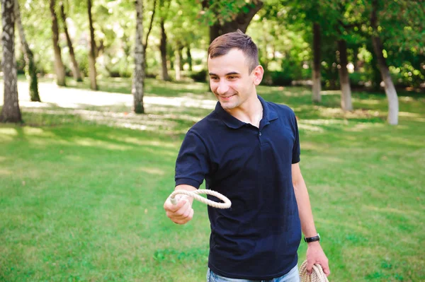 Outdoor games - guy playing ring toss in a park.