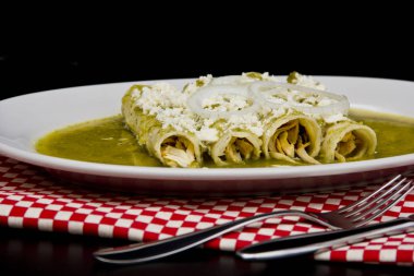 Meksika yeşil enchilada 'sı ile serrano acı sosu ve ekşi krema.