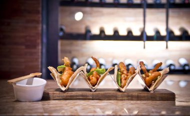 Balık tacoları ve acı soslu avokado dilimleri.