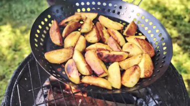 Yakın plan patatesler kömürde kızartılıyor. Sebzeleri kızartmak için kap. Yavaş çekim videosu 100fp. Yüksek kaliteli FullHD görüntüler