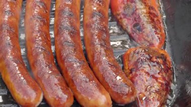 Yakın plan. Yemek hazırlama. Sıcak dökme demir tavada kızartılan sosisler. Yüksek kalite 4k görüntü