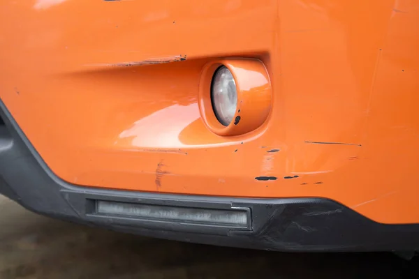 Car accident, Car insurance concept. Close up damaged of orange car bumper