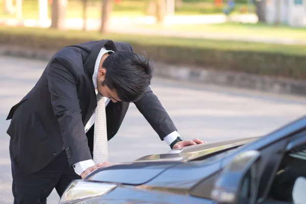 Handsome businessman with breakdown car on the road