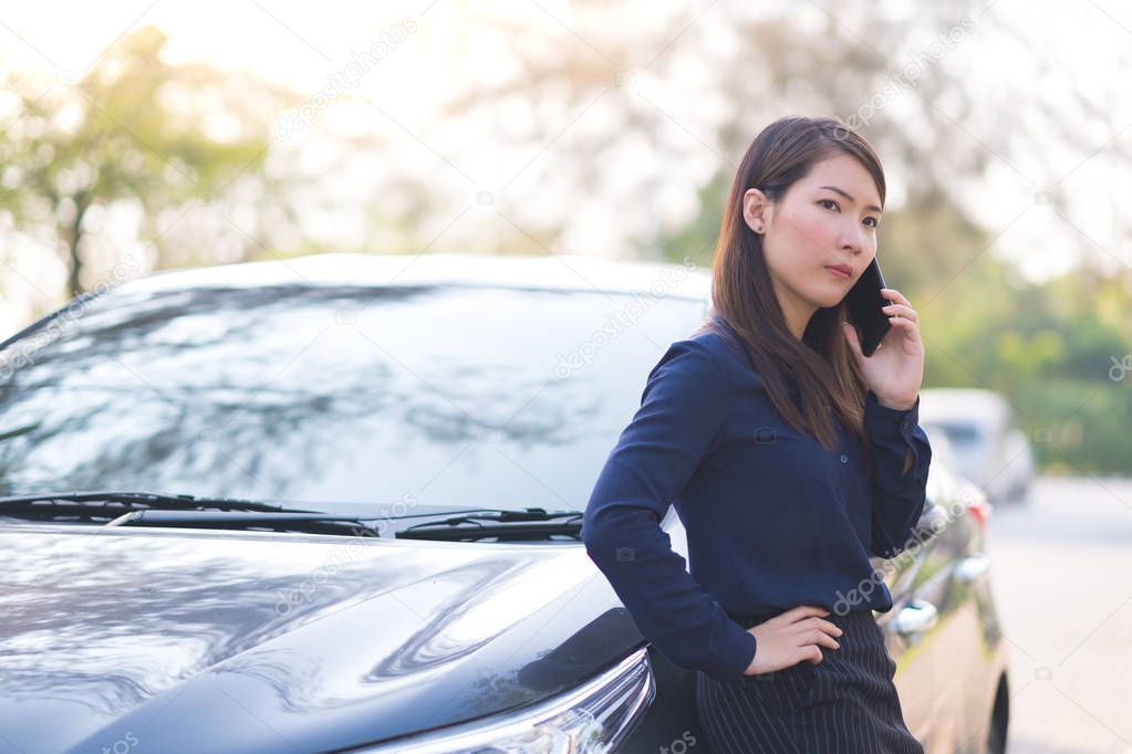 Young businesswoman stop a car and talking on phone for her business