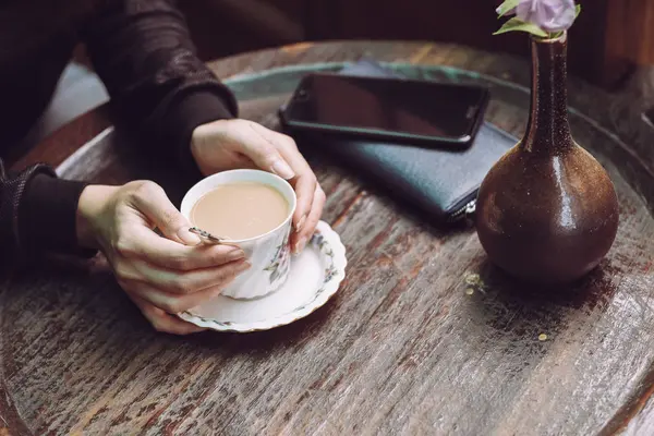 Coffee time, Hand holding coffee cup on table