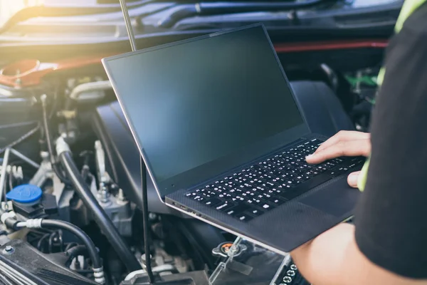 Bir arabayı akort etmek için elektrnotik tanı ekipmanı kullanan mühendis teknisyenini kapat