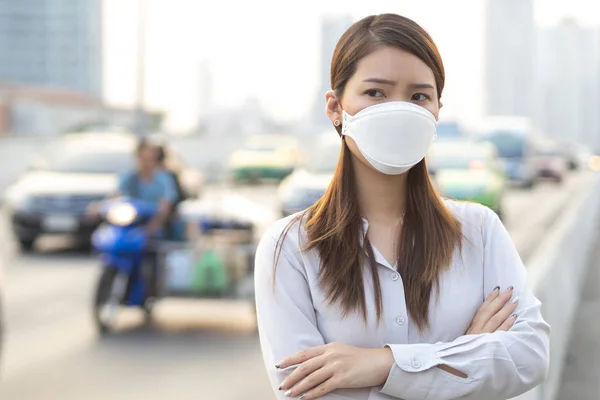 Şehir hava kirliliği kavramı. Şehirdeki PM2.5 hava kirliliğini korumak için N95 maskesi takan kadını kapatın.