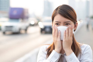 Şehir hava kirliliği kavramı. Şehirdeki PM2.5 hava kirliliğini korumak için N95 maskesi takan kadını kapatın.