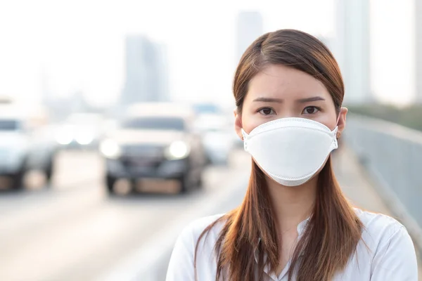 City air pollution concept. Close up woman wearing N95 mask to protect pm2.5 air pollution in city