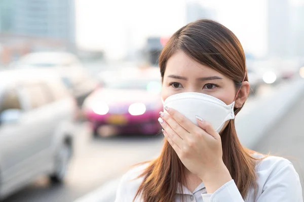 City air pollution concept. Close up woman wearing N95 mask to protect pm2.5 air pollution in city