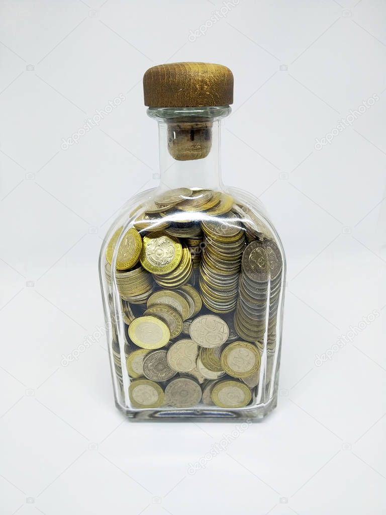 An isolated photo of a bottle with coins. Coins Kazakhstan tenge in a bottle. Kazakh money. Coins of tenge.