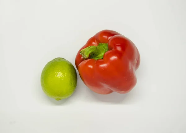 Beyaz arka plan üzerinde kırmızı biber ve kireç yeşil yukarıdan izole görünümü. Sebze