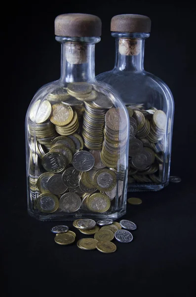 İzole fotoğraf sikkeleri üzerinde karanlık bir arka plan ile bir şişe. Paralar Kazakistan tenge karanlık bir arka plan üzerine bir şişe. Kazak para. Tenge sikkeleri.