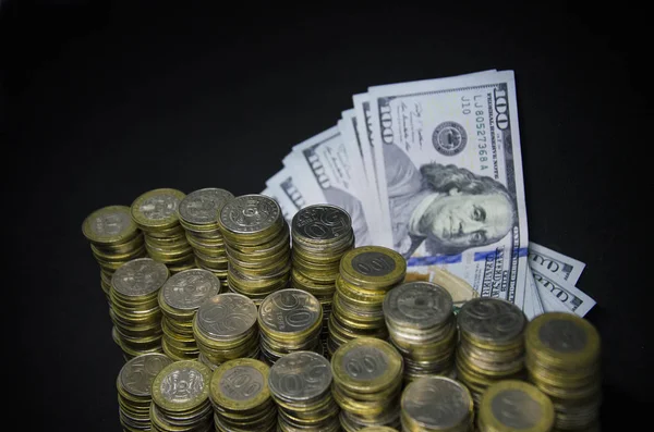 Koyu renkli bir arka plandaki sikkeler. Sikkekazakistan tenge karanlık bir arka plan üzerinde. Kazak parası. Tenge sikkeleri. sikke ve dolar kağıt banknotlar büyük kazık. Abd Doları ve Kazakistan tenge