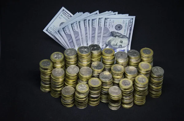 Koyu renkli bir arka plandaki sikkeler. Sikkekazakistan tenge karanlık bir arka plan üzerinde. Kazak parası. Tenge sikkeleri. sikke ve dolar kağıt banknotlar büyük kazık. Abd Doları ve Kazakistan tenge