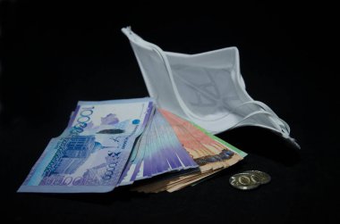 Kazak parası ve antiviral maske. Kazakistan bir salgın sırasında para ve para biriktirir. Kazakistan 'da Coronovirüs ve para. Tenge ve koronovirüs. Kazakistan ekonomisi ve COVID 19. Kazakistan bir tenge