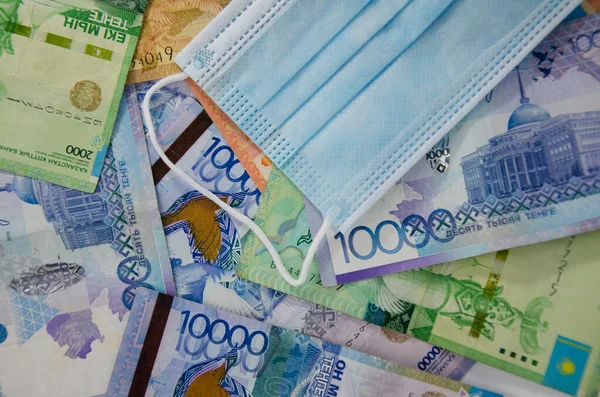 Composición Billetes Monedas Tenge Kazajo Una Máscara Médica Sobre Fondo — Foto de Stock