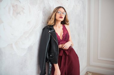 deri ceket ve çiçek desenli beyaz duvara poz gözlük ile genç çekici modeli