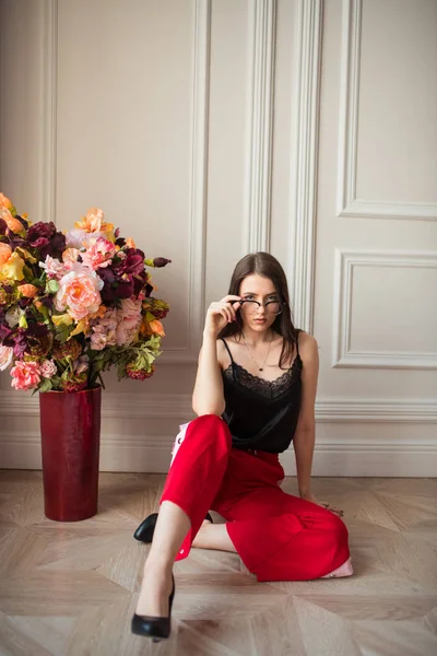 Stylish Fashion Model Eyeglasses Red Pants Posing Bouquet Flowers Floor — Stock Photo, Image