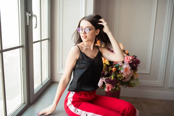 Stylish Young Woman Red Pants Posing Window Sill Flowers Indoors — Stock Photo, Image