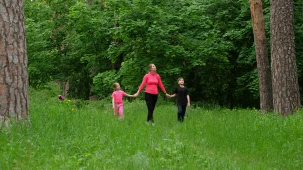 妈妈和孩子们在树林里散步。家庭体育运动的性质. — 图库视频影像