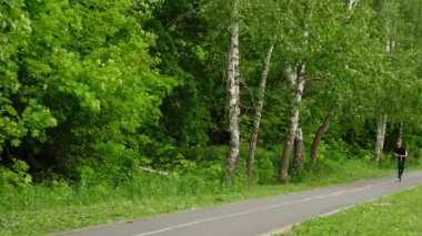 Ergen ormanda scooter 'a biniyor. Çocuk yolda sürmeyi öğreniyor..