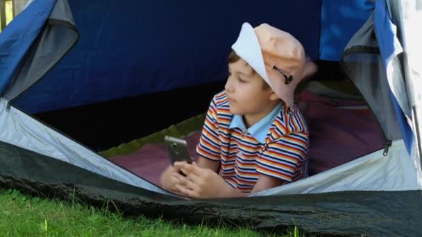 Criança Tira Uma Selfie Telefone Numa Tenda Menino Chapéu Tira — Vídeo de Stock