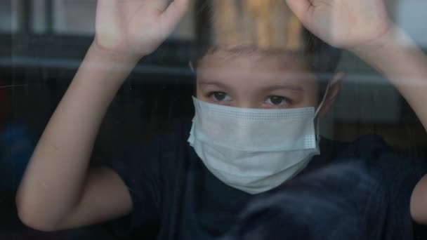 Rapaz Com Uma Máscara Médica Olha Pela Janela Auto Isolamento — Vídeo de Stock