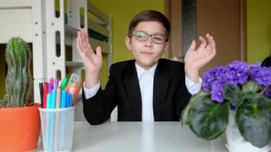 Gözlüklü küçük çocuk kameraya konuşuyor. Çocuk bilimsel video günlüğü tutuyor.