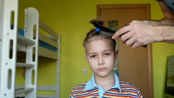 Young boy in a home barbershop. Dad haircuts it with scissors of little son. Coronavirus, quarantine, covid19. — Stock Footage Young Boy Home Barbershop Dad Haircuts Scissors Little Son Coronavirus Royalty Free Stock Video