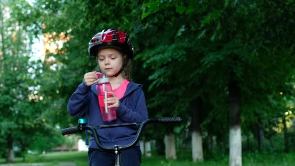 Mała Dziewczynka Pijąca Wodę Przy Rowerze Dziecko Kasku Jeżdżące Rowerze — Wideo stockowe