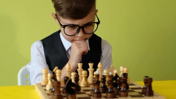 孩子们在桌上下棋 戴眼镜的小男孩制定国际象棋策略 和朋友玩棋盘游戏 — 图库视频影像