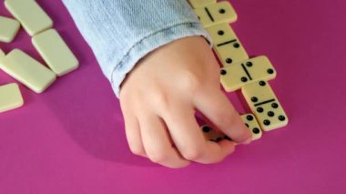 Çocuk evde vakit geçirirken domino oynuyor. Çocuklar masa oyunu oynarlar..