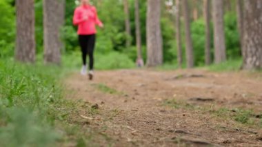 Ormanda koşan bir kız. Ayakkabı bağcığı bağlayan ve koşan bir kadın..