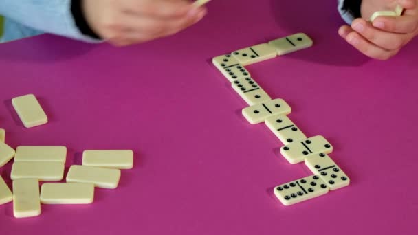 Çocuk evde vakit geçirirken domino oynuyor. Çocuklar masa oyunu oynarlar.. — Stok video