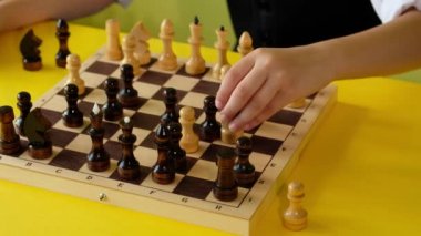 Evde birlikte vakit geçirirken gözlüklü çocuk satranç oynuyor. 