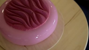 Ahşap tabanlı pembe ayna jöleli modaya uygun kremalı pasta. Modern tatlı..